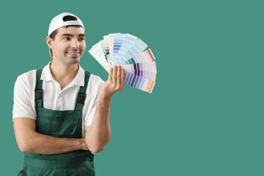 Male painter with color palettes on green background