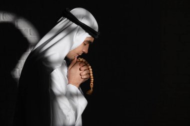 Praying Muslim man in dark room