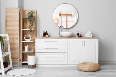 Interior of light bathroom with counters, sink and mirror
