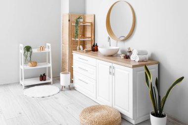 Interior of light bathroom with counters, sink and mirror