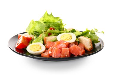 Plate of delicious salad with boiled eggs and salmon isolated on white background