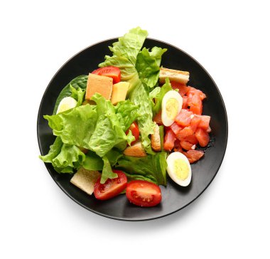Plate of delicious salad with boiled eggs and salmon isolated on white background