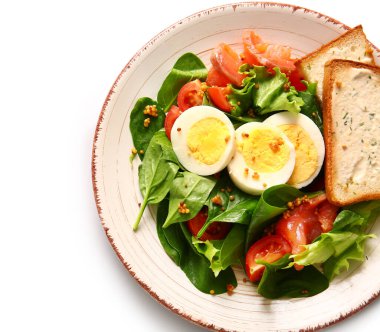 Plate of delicious salad with boiled eggs and salmon on white background