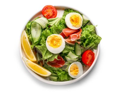 Plate of delicious salad with boiled eggs and jamon isolated on white background
