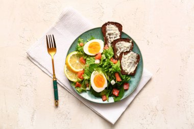 Plate of delicious salad with boiled eggs and salmon on white grunge background