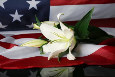 USA flag with lilies on table. National Day of Prayer and Remembrance for the Victims of the Terrorist Attacks