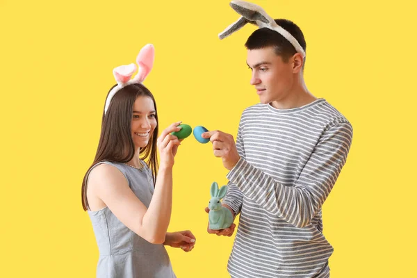 Šťastný Mladý Pár Zajíček Uši Velikonočními Vejci Králík Žlutém Pozadí — Stock fotografie