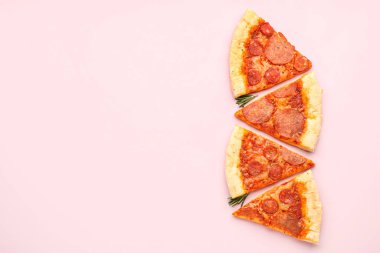 Slices of delicious pepperoni pizza on pink background