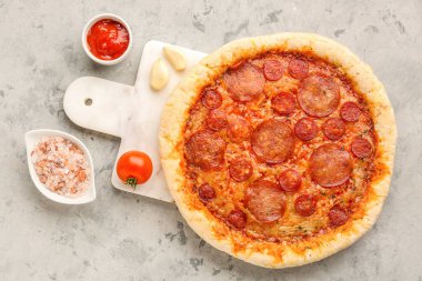 Board with delicious pepperoni pizza on grey grunge background