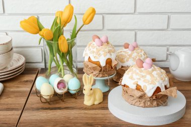 Easter cakes, tulip flowers and painted eggs on kitchen counter
