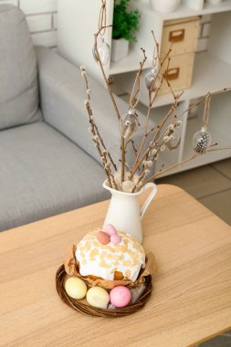 Easter cake, painted eggs and bunny on table in living room