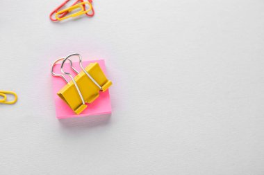 Binder clip and sticky notes on grey background