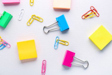 Binder clips and sticky notes on grey background