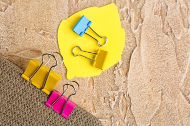 Notebook, binder clips and sticky notes on color background, closeup