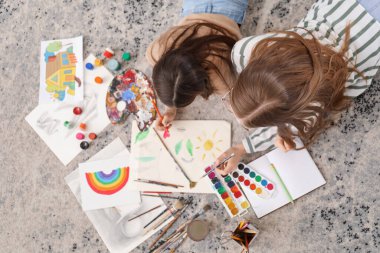 Drawing teacher giving private art lesson to little girl at home, top view