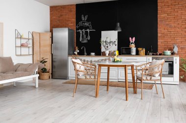 Interior of kitchen with Easter decor, counters and dining table