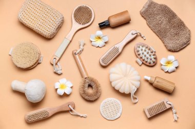 Composition with different bath supplies, cosmetic products and flowers on color background