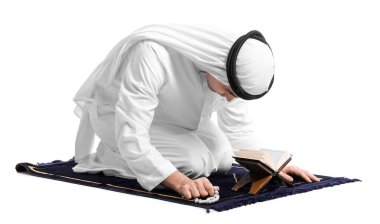 Praying Muslim man with Koran on white background