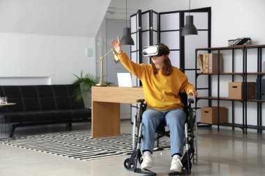 Young woman in wheelchair using VR glasses in office