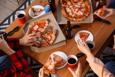 Group of friends with tasty pizza and drinks at home, top view