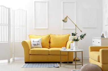 Interior of light living room with flowers in vase and sofa