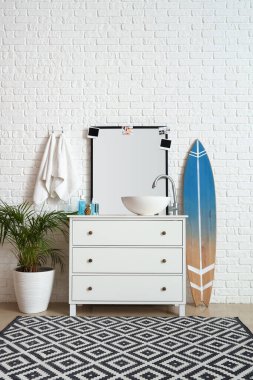 Interior of bathroom with sink, drawers and surfboard