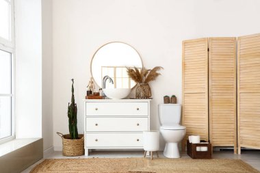Interior of light bathroom with sink, mirror and toilet bowl