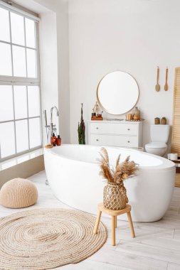 Interior of light bathroom with bathtub, sink and toilet bowl