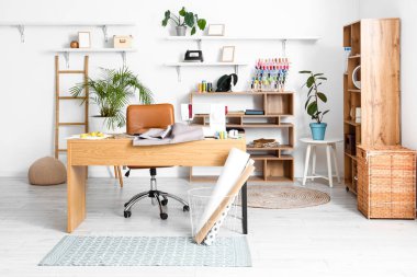 Interior of modern atelier with tailor's workplace and shelving units