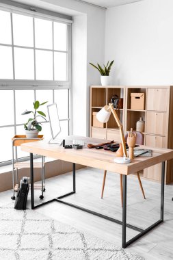 Tailor's workplace with computer, lamp and male accessories in atelier
