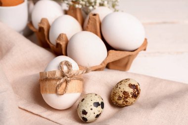Easter and quail eggs on white wooden background