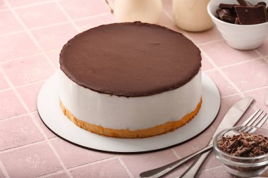 Tasty birds milk cake and chocolate on color tile table