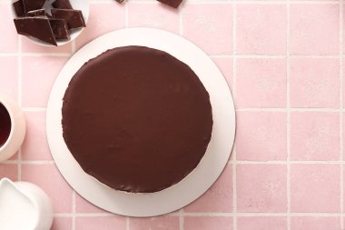 Delicious birds milk cake and chocolate on color tile background