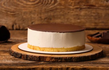 Board with tasty birds milk cake on wooden table