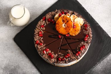 Slate board with delicious birds milk cake on black and white background, closeup