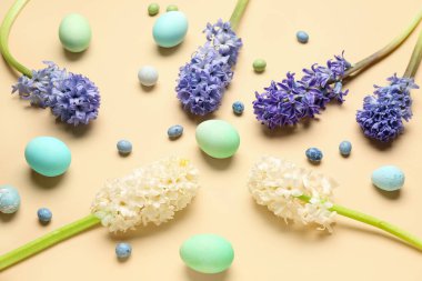 Composition with beautiful hyacinth flowers and Easter eggs on beige background