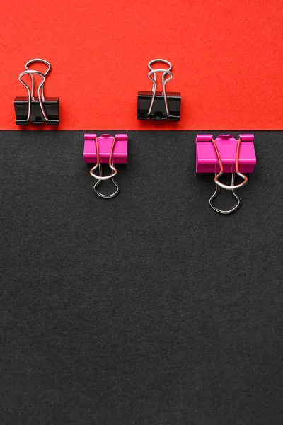 Binder clips on color background