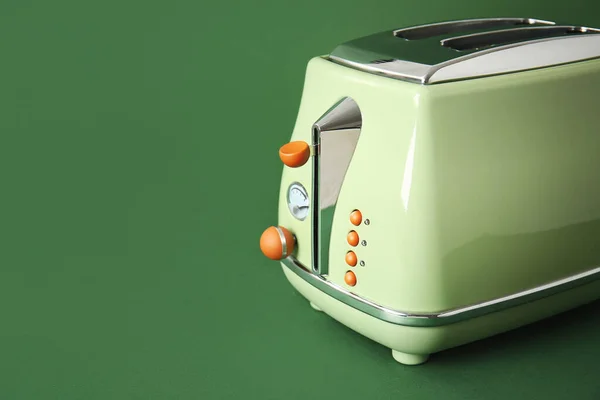 Modern toaster on green background