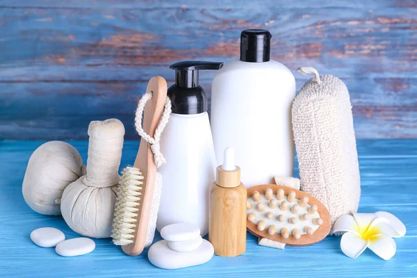 Set of bath supplies and cosmetic products on color wooden background