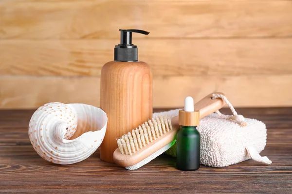 Bottles Cosmetic Products Bath Sponge Massage Brush Seashell Wooden Background — Stock fotografie