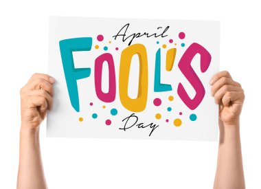 Beyaz arkaplanda AYRIL FOOLS GÜNÜ yazılı afiş tutan eller
