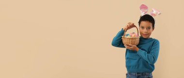 Tavşan kulaklı komik Afro-Amerikalı çocuk ve bej arka planda paskalya sepeti, mesaj için yeri var.