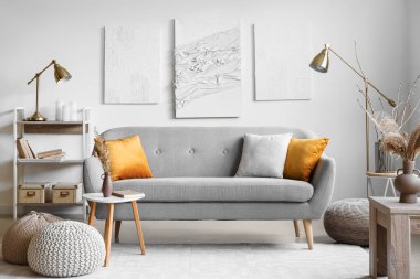 İçinde kanepe, lambalar ve yaratıcı sanat eserleri olan modern oturma odası.