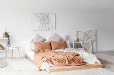 Büyük yataklı, yaratıcı sanat eserleri olan modern bir oda.