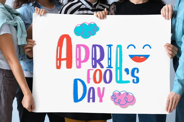 Group of people holding poster with text APRIL FOOLS DAY
