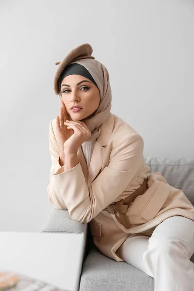 时髦的穆斯林妇女坐在家里的沙发上 — 图库照片