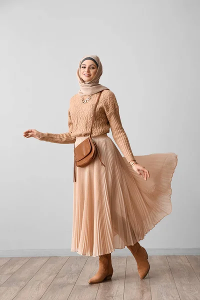米色头巾中穿着时髦的穆斯林妇女 手提包靠近轻墙 — 图库照片