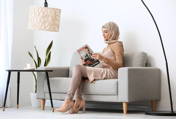Mulher Muçulmana Bonita Ler Revista Sofá Casa — Fotografia de Stock
