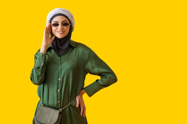 戴着黄色背景太阳镜的时髦穆斯林妇女 — 图库照片