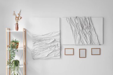 Yaratıcı sanat eserleri ve odadaki ışık duvarında asılı boş çerçeveler